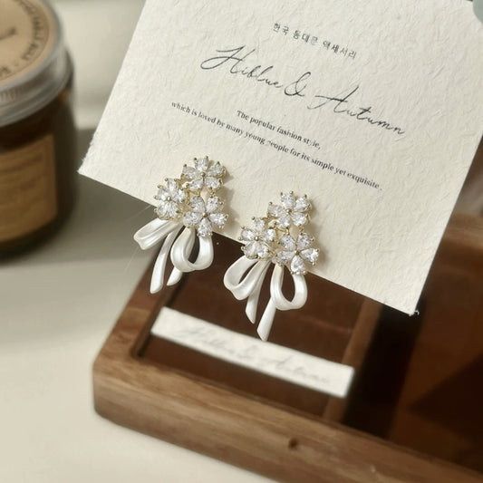 Holding a flower ribbon bow zircon earrings