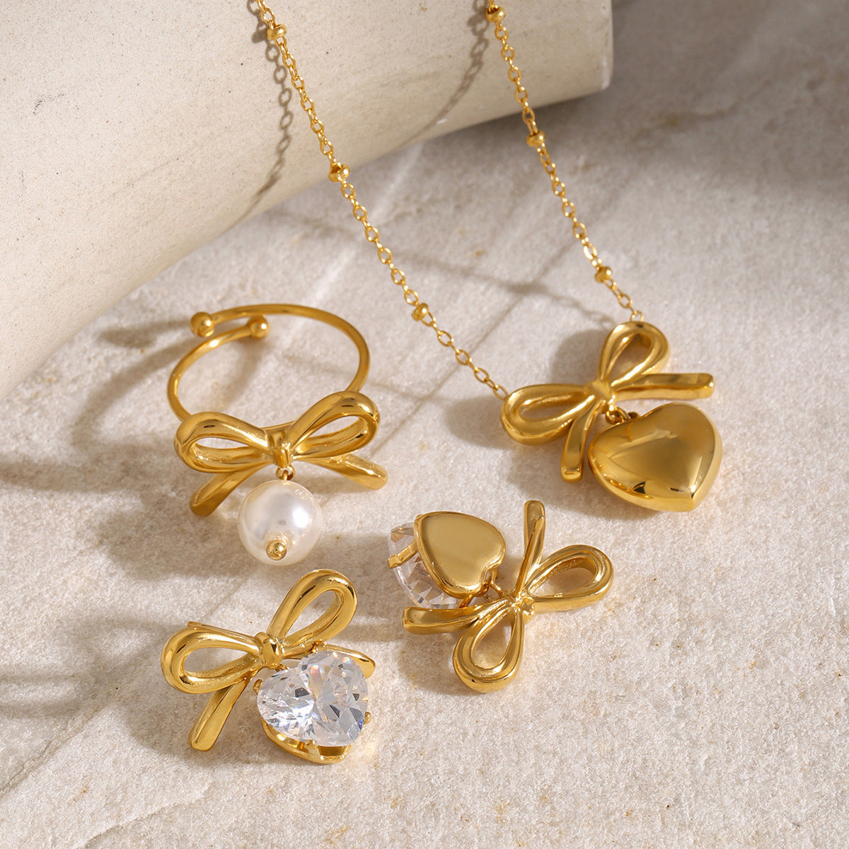 ステンレススチールのリボンネックレス、ジルコンのイヤリング、チタンスチールリング